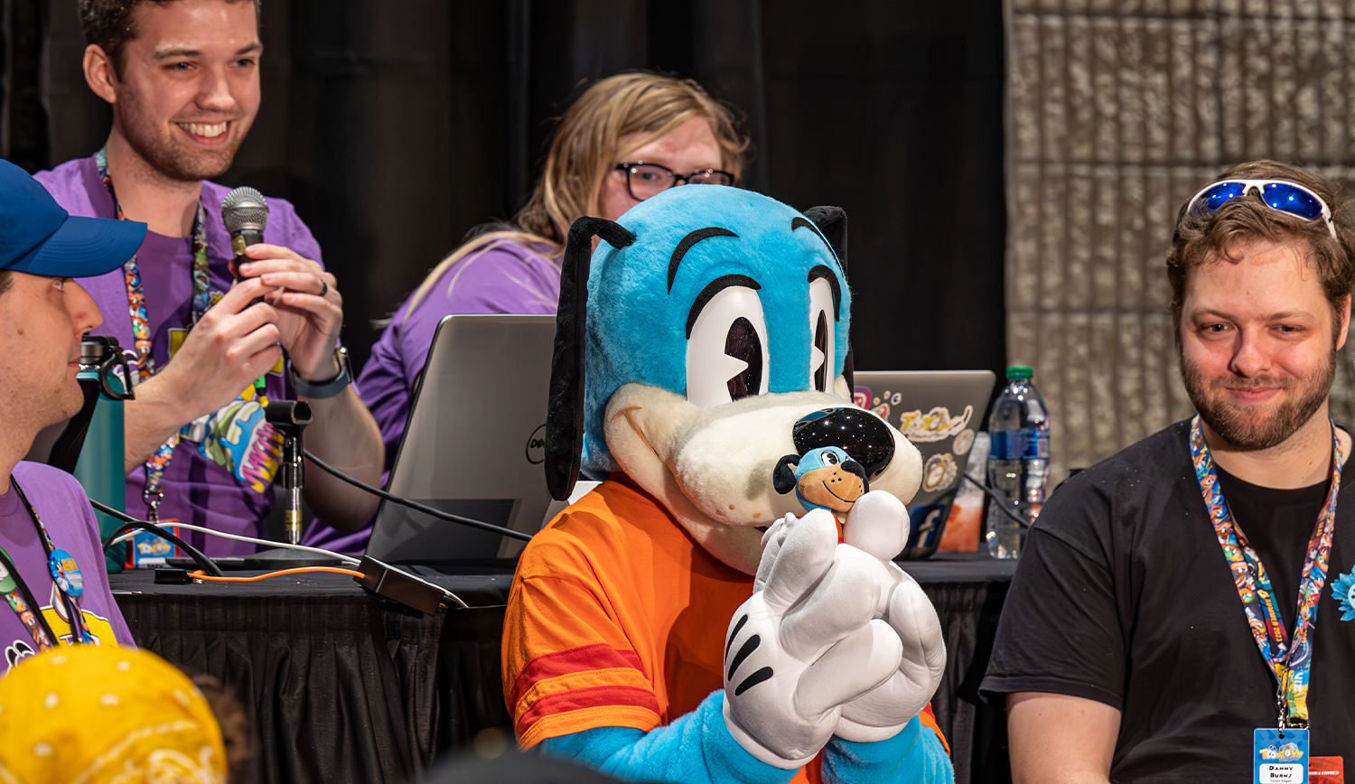 Flippy Doggenbottom holds a plushie of himself to the audience